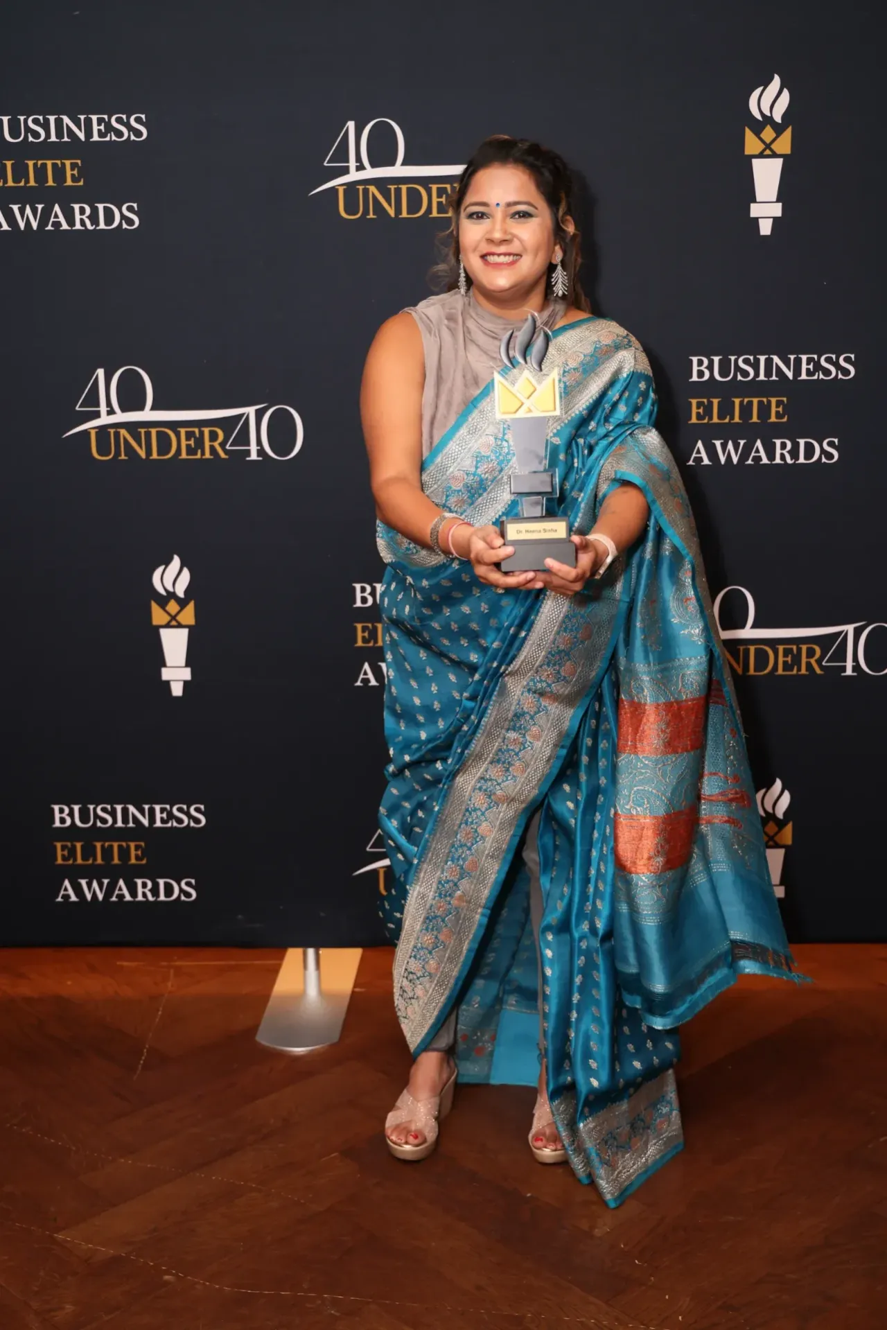 Dr Heena Sinha Cheung holding her 2024 40 Under 40 award trophy.